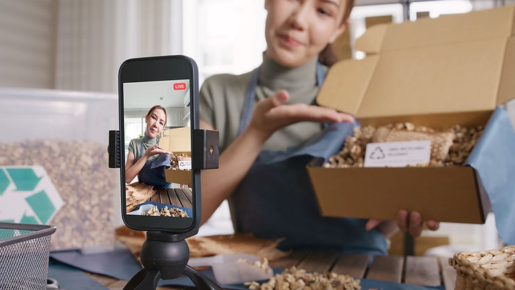 A woman streaming live talking on a phone showing eco care plastic packaging